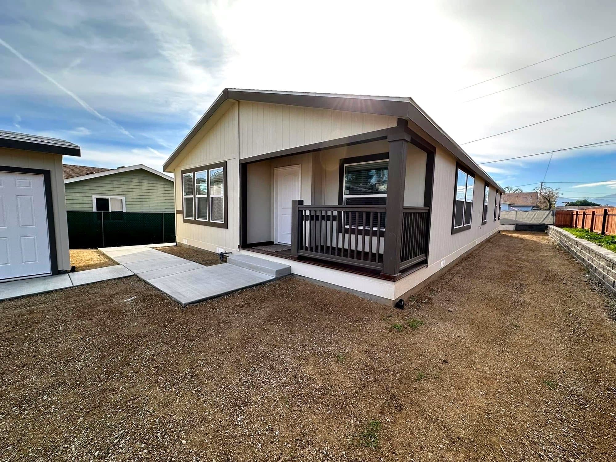 Cream manufactured home with a dark brown covered porch